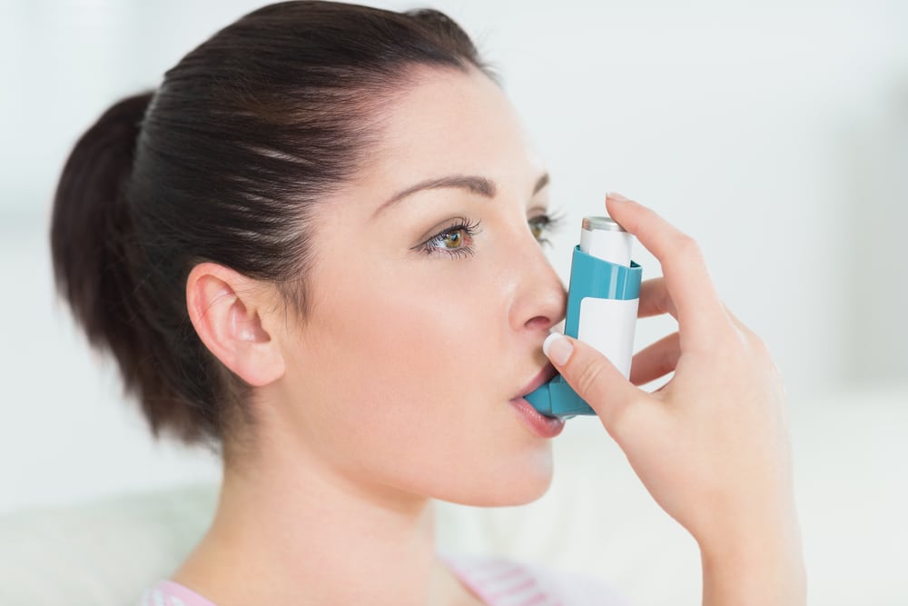 woman using an inhaler for her asthma