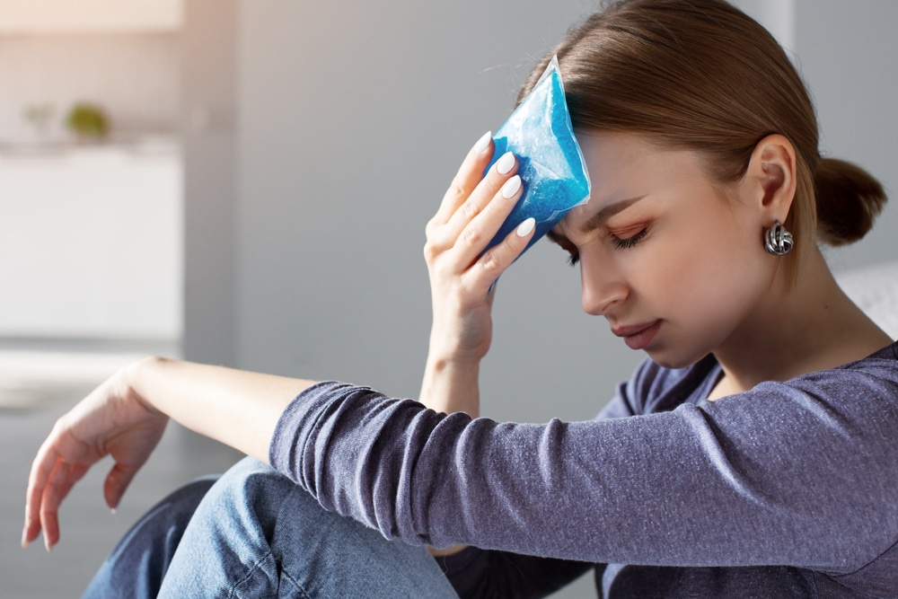 Woman using ice pack for tension headache